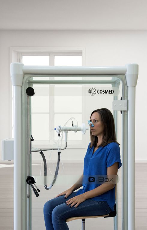 Q-Box - Femme pendant un test de pléthysmographie corporelle à l'intérieur de la cabine